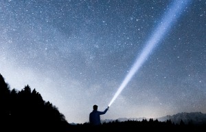 person shining torch into sky