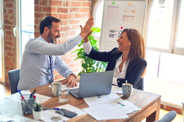 Business man and woman celebrate with high five